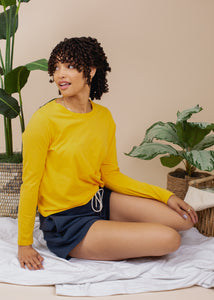 woman wearing basic long sleeve jersey top in gold