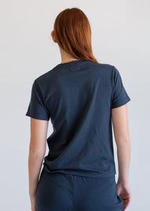Person wearing a navy blue t-shirt and shorts set against a plain background