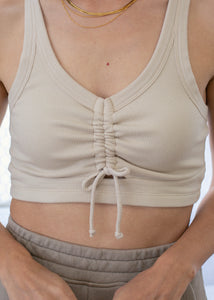 close up of woman wearing crop rib tank with front ruche detail in natural