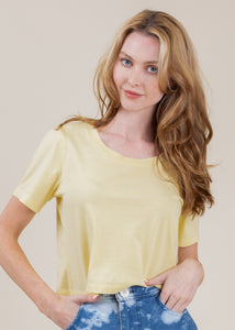 woman wearing cropped tee with open neck in yellow