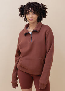 woman wearing half zip sweatshirt in brick