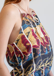Person wearing a patterned top against a plain background