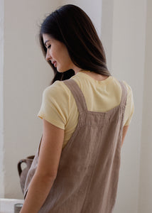 back of woman wearing linen overall in mushroom