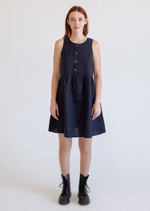 Woman wearing a navy sleeveless dress on a white background