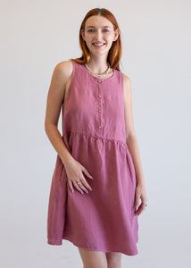 Woman wearing a pink dress against a plain background