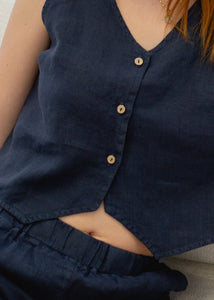 Navy blue sleeveless vest with buttons on a neutral background