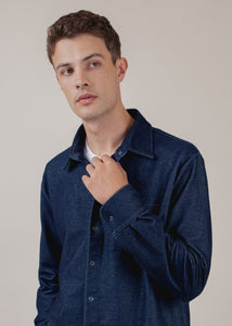 close up of man wearing long sleeve indigo button down with LA patch
