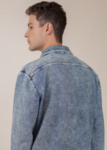 back of man wearing long sleeve indigo button down in mineral wash