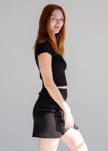 Woman wearing a black outfit on a gray background