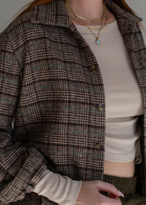 Person wearing a plaid shirt over a white top