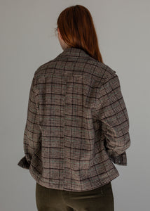 Person wearing a plaid shirt against a gray background