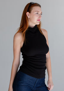 Woman wearing a black sleeveless top against a gray background