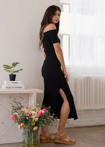 side view of woman wearing off shoulder rib dress in black