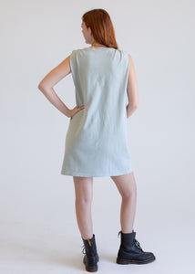 Woman wearing a light blue boxy tank dress against a white background