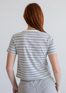 Person wearing a striped shirt from behind on a plain background