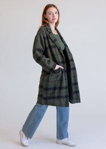Woman wearing a green plaid coat on a white background