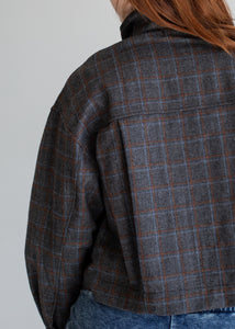 Plaid jacket worn by a person on a plain background
