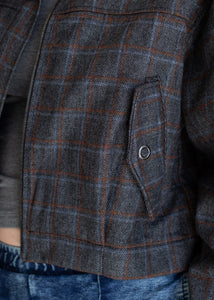 Close-up of a gray and brown checkered jacket with a pocket.